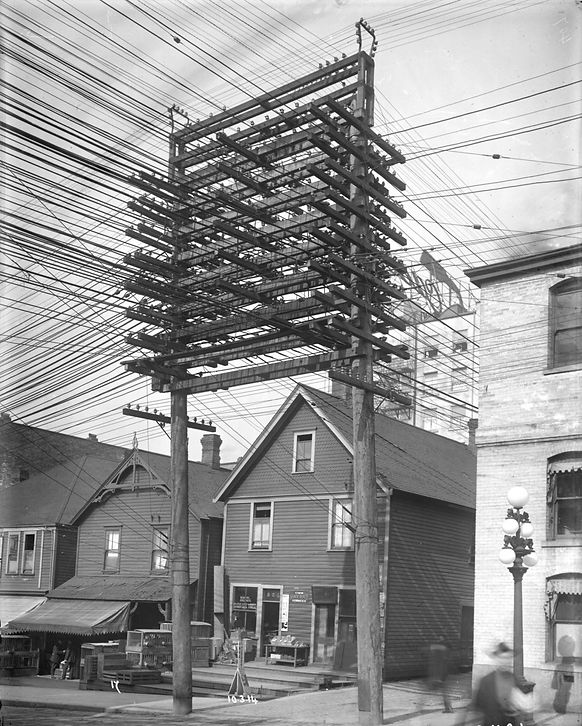 Monster telephone poles with dozens of attachments, from the early 1900s